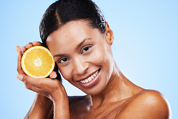 Image showing Skincare, beauty and orange fruit for black woman in studio for cosmetics, vitamin c and dermatology benefits with water drops on skin. Portrait, face and smile of model with natural product for skin