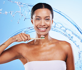 Image showing Black woman, toothbrush or smile with water splash for health skincare, wellness or dental teeth in blue studio background. Happy portrait of African girl brushing teeth for beauty or toothpaste