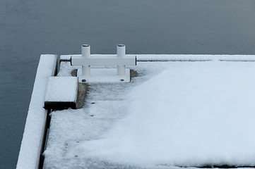 Image showing snow-covered quayside with construction for mooring boats