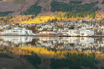 Image showing small town mirrors in the sea with a streak of sun