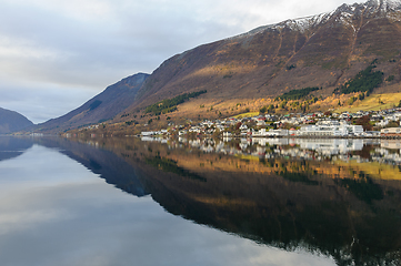 Image showing small town mirrors in the sea with a streak of sun