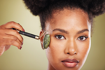 Image showing Skincare, beauty and black woman with face roller, facial massage for glowing healthy skin. Wellness, dermatology and relax, portrait of woman with jade roller for anti aging treatment in studio