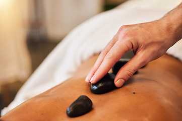 Image showing Hot stone massage, spa and skincare for wellness, health and physical therapy to relax in luxury. Mind, body and spirit wellness with rock therapy on skin in closeup with oil, zen or natural cosmetic