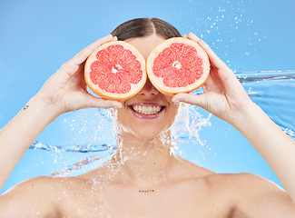 Image showing Grapefruit, portrait and woman in studio face, water splash and wellness promotion for skincare, detox and shower. Beauty model cover eyes with vitamin c fruits or healthy food on eyes for nutrition