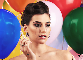 Image showing Party balloon and makeup woman crying with sad, depressed and disappointed tears on face. Thinking, depression and mental health problem of girl at event smoking cigarette with sadness.