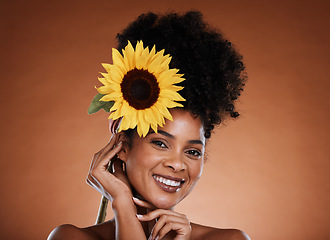 Image showing Flower, beauty and woman or portrait for skincare, haircare and natural health or wellness. Sunflower, nature and black woman on a brown studio background for organic skin care or bodycare