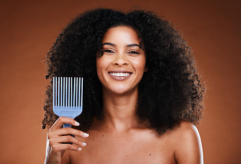 Image showing Black woman, hair care and smile in portrait with comb, afro pick or beauty against brown backdrop. Happy African, model and woman with cosmetics, makeup or happiness for combing by studio background