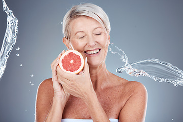 Image showing Wellness, beauty and grapefruit woman with water splash for body care, skincare and health cosmetics marketing. Clean, happy and healthy senior model for cosmetic advertising on gray studio mockup.