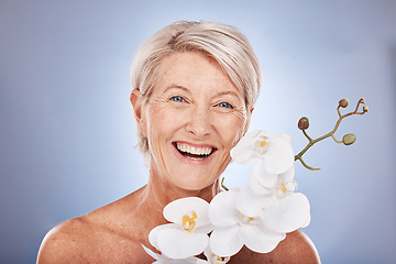 Image showing Face, beauty and flowers with a mature woman in studio on a gray background with an orchid for natural care. Portrait, cosmetics and plant with a senior female posing to promote the benefit of nature