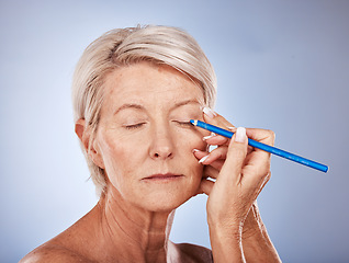 Image showing Makeup, beauty and senior woman with eyeliner for color on face against a grey studio background. Cosmetic, skin and elderly model with a pencil for facial cosmetics, natural art and creativity