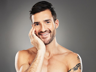 Image showing Face, beauty and portrait with a man model in studio on a gray background for skincare, wellness or luxury. Portrait, cosmetics and tattoo with a handsome young male posing to promote natural care