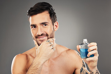 Image showing Man, perfume and cologne product in studio for hygiene, fresh scent and fragrance on gray background. Parfum, wellness and happy male model thinking about spray cosmetics to prevent odor or smell.