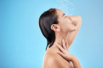 Image showing Skincare, woman and shower with water, for wellness and body care against blue studio background. Female, girl and wet for cleaning, washing and splash for hygiene, health and grooming to relax.