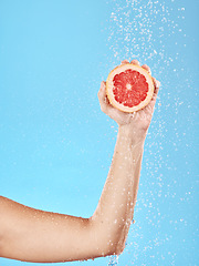 Image showing Grapefruit, arm and shower for natural healthcare or skincare cleaning. Luxury fruit, skin beauty and model hand with vitamin c wellness for tropical nutrition under water in blue background studio