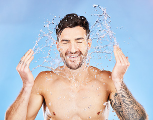 Image showing Skincare, water and facial man beauty routine for grooming, hygiene and cleaning routine with smile. Wellness, water splash and health of happy skin model in blue studio with satisfied face.