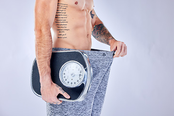 Image showing Motivation, health and weight loss, man with scale checking change from diet, workout and healthy lifestyle on studio background. Fitness, nutrition and wellness, balance in body care for male model.