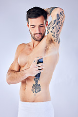 Image showing Beauty, fresh and deodorant with a man model spraying perfume to his underarm in studio on a gray background. Product, body and armpit fragrance with a handsome young male in the bathroom alone