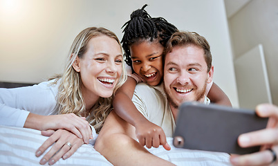 Image showing Family, selfie and happiness on bed for social media profile picture or post about adoption, love and support of parents for foster child. Man, woman and girl together in bedroom with smartphone