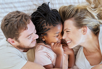 Image showing Family, interracial and love, happy and together with adoption or foster care overhead and bonding together in family home. Happy family lying on bed, cuddle and smile with mother, father and child.