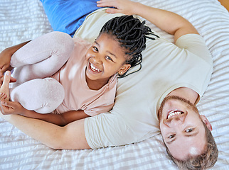 Image showing Family, portrait and smile while on bed to relax, love and trust after adoption with father and foster child in home bedroom for quality time. Man and girl from top while bonding, happy and together