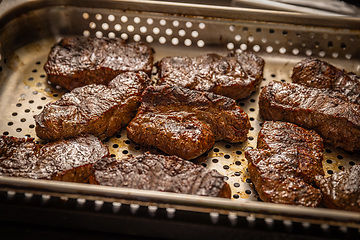 Image showing Pieces of grilled steak with fat