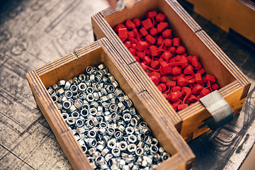 Image showing Metal nut with metric thread in wooden box