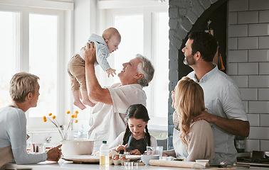 Image showing .Family, kitchen and grandpa playing with baby having fun, bonding and relax together. Big family, support or care of grandfather carrying newborn with mother, father and girl child cooking in house.