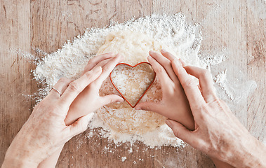Image showing .Hands, baking and heart shape with a girl and grandmother learning how to bake in the kitchen of their home together. Family, children and food with a woman and granddaughter bonder over cooking.