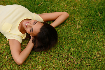 Image showing Happy woman relax on park grass, garden and nature, freedom or rest on summer lawn with mockup. Above of young girl lying on green field outdoor in sunshine for calm, peace and mental health wellness