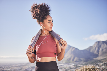 Image showing Fitness, towel and black woman with earphones in nature after running, workout or training. Health, wellness or female streaming music, radio or podcast, audio or song on break after exercising alone