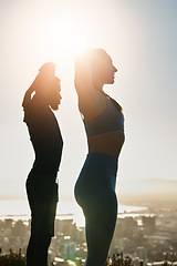 Image showing Fitness, sunset and couple doing an outdoor exercise or training together on a rooftop in the city. Sports, healthy and athletes stretching before workout on roof of a building outside in urban town.