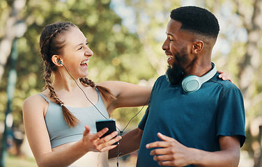 Image showing Headphones, fitness and couple with phone in nature on break after workout, running or training. Sports, diversity and man and woman streaming music, radio or podcast outdoors on 5g mobile smartphone