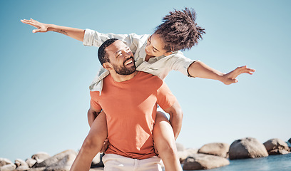 Image showing Travel, happy and beach with couple and piggy back for freedom, summer and bonding. Smile, playful and airplane with man carry woman by ocean for love affection, energy and adventure on holiday