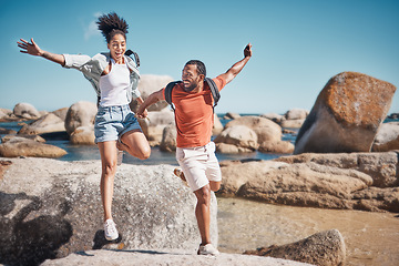 Image showing Beach, freedom and happy couple jumping on rocks together while on seaside summer vacation. Happiness, travel and young man and woman in nature by the ocean on holiday, adventure or journey in Mexico