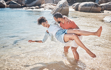 Image showing Couple, love and man carrying woman on beach for funny, comic or relax travel adventure together. Happiness, support and african person carry wife, quality time in water for Hawaii summer vacation