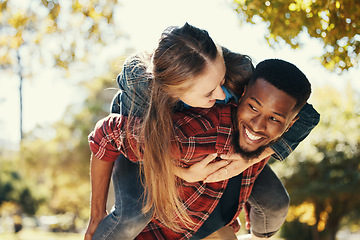 Image showing Piggy back, couple and love in park, smile and happy on date, romance and fun together in spring nature. Interracial man and woman happiness, play or relationship outdoor in forest, care or woods