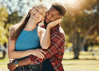 Image showing Couple, love and hug outdoor, park and happy smile, romance and relax on date or care. Interracial black man and woman together, happiness or romantic affection, smiling or enjoy relationship