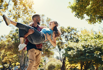 Image showing Young interracial couple, park and man carrying woman on summer date in garden, sunshine fun or relax, love and care together. Happy couple, smile and diversity people in nature for relationship play