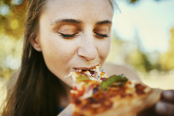 Image showing Eating, pizza and hungry with a woman biting a slice of fast food outdoor in a park or garden on the weekend. Food, bite and lunch with a young female enjoying a snack outside for her hunger