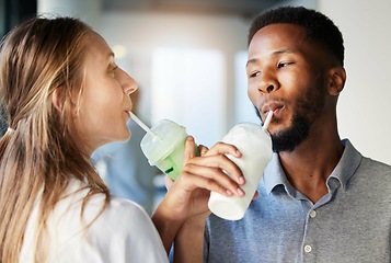 Image showing Restaurant, date and couple drinking a milkshake together while at a romantic summer adventure. Happy, love and interracial man and woman enjoying a smoothie at a cafe or coffee shop in the city.