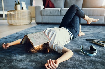 Image showing Education, tired and book with a woman student lying on the floor of her living room, sleeping in a home. Learning, exhausted and reading with a female college pupil asleep in a house while studying