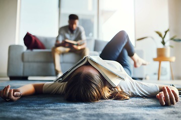 Image showing Burnout, tired and student with book on face laying on floor after studying, reading and working on project. Education, university and woman exhausted, stressed and sad from college in living room