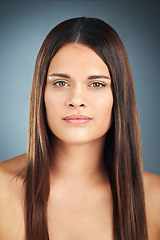 Image showing Face, hair and beauty with a model woman in studio on a blue background for natural haircare treatment. Portrait, hair care and skincare with an attractive female posing to promote a keratin product