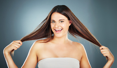 Image showing Hair care, beauty and woman with hair in hands for growth on gray background studio. Hair salon, spa and portrait of girl with long, healthy and natural style after treatment, products and cosmetics