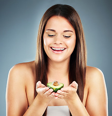 Image showing Woman, beauty and fruit with smile for skincare, nutrition or cosmetics against a studio background. Happy female holding avocado and smiling in satisfaction for natural, organic or healthy treatment