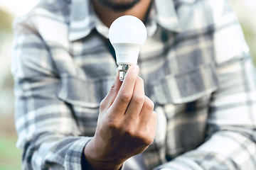 Image showing Energy, nature and hand of man with light bulb for conservation innovation, engineering or creativity. Eco, bulb and idea of outdoor person for sustainability, green energy and development.