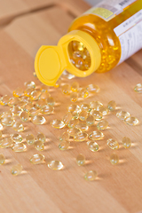 Image showing Fish oil omega pills spilled from a bottle