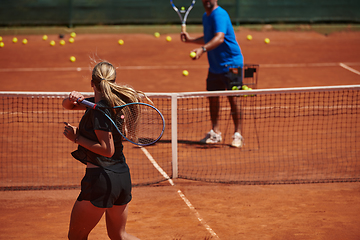 Image showing A professional tennis player and her coach training on a sunny day at the tennis court. Training and preparation of a professional tennis player