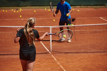 Image showing A professional tennis player and her coach training on a sunny day at the tennis court. Training and preparation of a professional tennis player