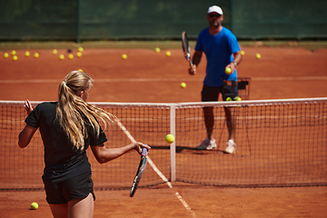 Image showing A professional tennis player and her coach training on a sunny day at the tennis court. Training and preparation of a professional tennis player